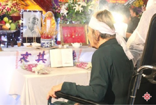 Bà Phạm Thị Vân lặng lẽ ngồi trước di ảnh chồng trong đám tang nhạc sĩ Phan Huỳnh Điểu vào đầu tháng 7.2015.