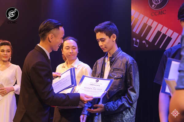 Nhạc sĩ Nguyễn Thiên Phúc trao giấy chứng nhận cho học viên xuất sắc trong một chương trình lớn của trung tâm âm nhạc cộng đồng Cecelia.