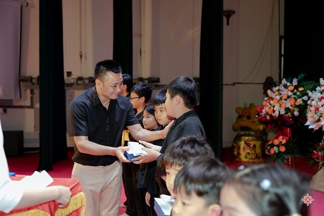 Nghệ sĩ nhân dân Vũ Tự Long - Phó Giám đốc Nhà hát Chèo Quân đội trao đai cho các võ sinh.